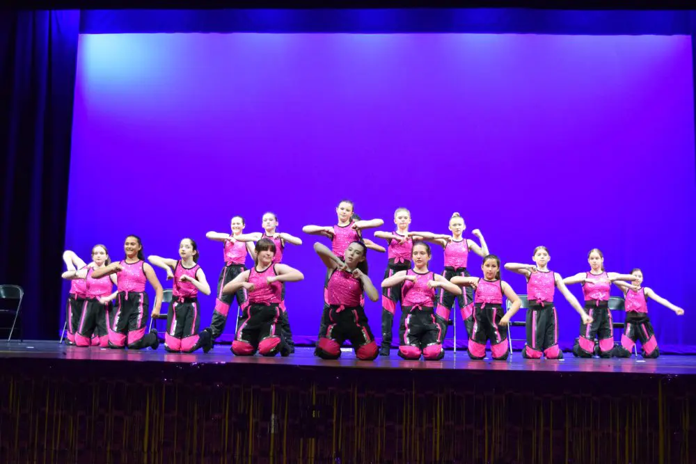 A group of young people on stage performing.