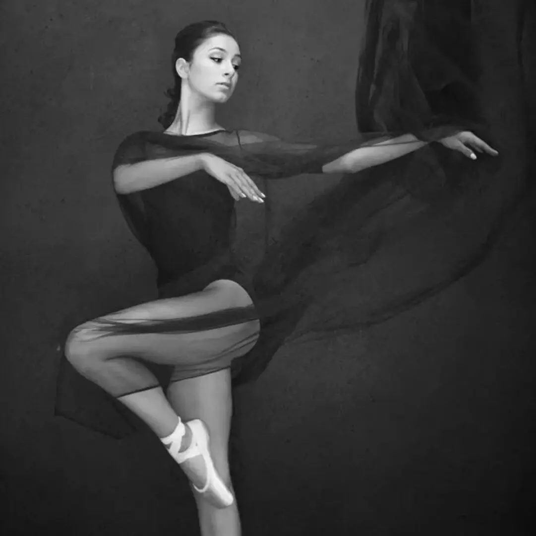 A woman in black leotard and tights doing ballet.