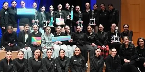 A group of women holding trophies and posing for the camera.