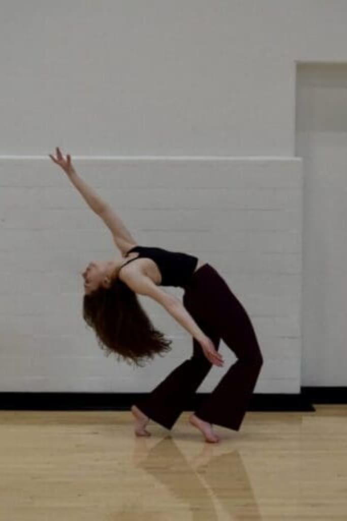 Contemporary dancer arching back in studio